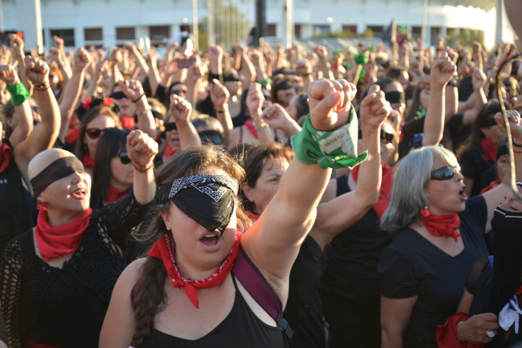 Mujeres en las manifestaciones feministas con el puño en alto y los ojos vendados